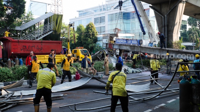 Petugas membongkar Jembatan Penyeberangan Orang (JPO) Tendean yang rusak usai tertabrak truk pengangkut alat berat di kawasan Tendean, Jakarta, Selasa (14/7/2026). [Suara.com/Alfian Winanto]