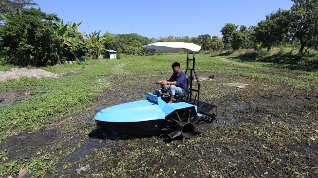 Mahasiswa Fakultas Vokasi, Departemen Teknik Elektro Otomasi Institut Teknologi Sepuluh Nopember (ITS) Cahya Dwi Budiharjo menguji coba traktor perahu listrik di area persawahan kampus ITS, Surabaya, Jawa Timur, Selasa (14/7/2026). [ANTARA FOTO/Moch Asim/YU]