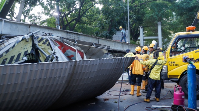 Petugas membongkar Jembatan Penyeberangan Orang (JPO) Tendean yang rusak usai tertabrak truk pengangkut alat berat di kawasan Tendean, Jakarta, Selasa (14/7/2026). [Suara.com/Alfian Winanto]