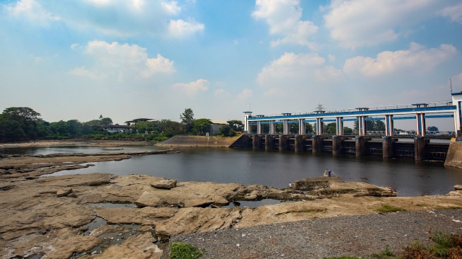 Seorang warga mencari ikan di tengah Sungai Cisadane yang mulai mengering di Tangerang, Banten, Rabu (15/7/2026). [ANTARA FOTO/Muhammad Iqbal/tom]