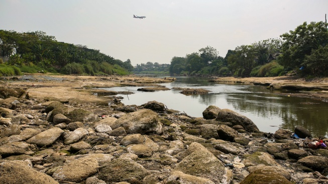 Sebuah pesawat melintas di atas Sungai Cisadane yang mulai mengering di Tangerang, Banten, Rabu (15/7/20236). [ANTARA FOTO/Muhammad Iqbal/tom]