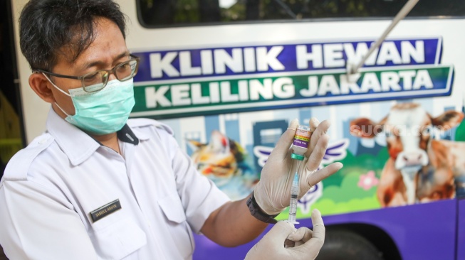 Petugas menyiapkan suntikan vaksin untuk hewan peliharaan yang diperiksa di mobil Klinik Hewan Keliling Jakarta, di Jakarta, Rabu (15/7/2026). [Suara.com/Alfian Winanto]