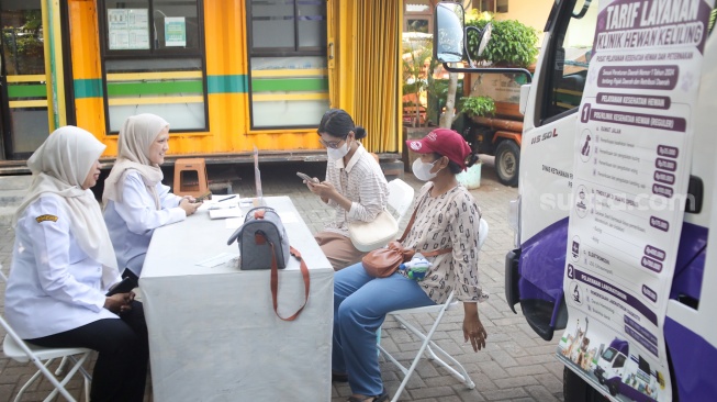 Warga membawa hewan peliharaannya untuk diperiksa di mobil Klinik Hewan Keliling Jakarta, di Jakarta, Rabu (15/7/2026). [Suara.com/Alfian Winanto]