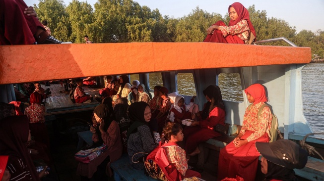 Sejumlah siswa SDN 02 Desa Pantai Bahagia berada di atas perahu melintasi Sungai Citarum saat berangkat ke sekolah di Muara Gembong, Kabupaten Bekasi, Jawa Barat, Kamis (16/7/2026). [ANTARA FOTO/Darryl Ramadhan/YU]
