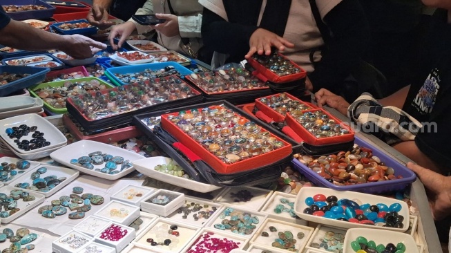 Para pengunjung meluhat mencari bacin yang menarik di anatara kumpulan batu cincin yang dijual di salah satu outlet di Gedung Jakarta Gems Center (JGC) Rawa Bening, Jatinegara, Jakarta Timur, Kamis (16/7/2026). (Suara.com/Cornelius Juan Prawira)