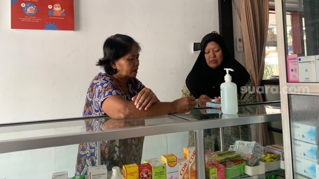 Warga Tamanmartani, Kristina, saat membeli kebutuhan obat di Apotek Klinik KDMP Tamanmartani pada Senin (21/7/2026). (Suara.com/Irwan Febri)