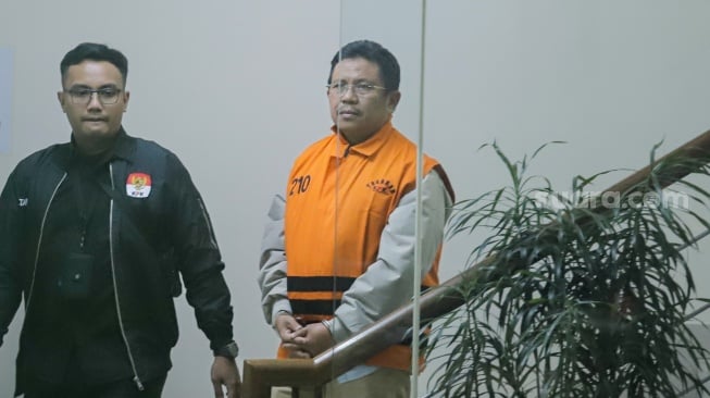 Bupati Lombok Barat Lalu Ahmad Zaini berjalan menuju mobil tahanan usai menjalani pemeriksaan di Gedung Merah Putih KPK, Jakarta, Selasa (21/7/2026). [Suara.com/Alfian Winanto]