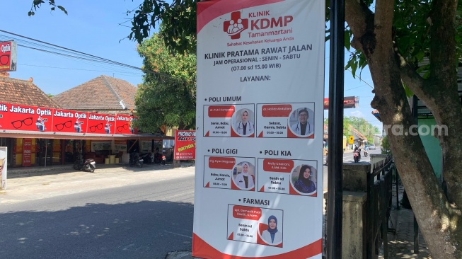 Papan nama Klinik KDMP Tamanmartani yang berisikan informasi jam pelayanan dan tim tenaga medis. (Suara.com/Irwan Febri)