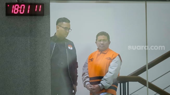 Bupati Lombok Barat Lalu Ahmad Zaini berjalan menuju mobil tahanan usai menjalani pemeriksaan di Gedung Merah Putih KPK, Jakarta, Selasa (21/7/2026). [Suara.com/Alfian Winanto]