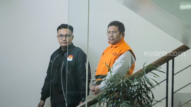 Bupati Lombok Barat Lalu Ahmad Zaini berjalan menuju mobil tahanan usai menjalani pemeriksaan di Gedung Merah Putih KPK, Jakarta, Selasa (21/7/2026). [Suara.com/Alfian Winanto]