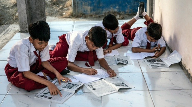 Sejumlah siswa kelas 5 mengerjakan tugas saat kegiatan belajar mengajar di musala yang digunakan sebagai ruang belajar sementara akibat ambruknya atap ruang kelas di SD Negeri Tanggirejo, Tegowanu, Grobogan, Jawa Tengah, Selasa (21/7/2026). [ANTARA FOTO/Aprillio Akbar/YU]
