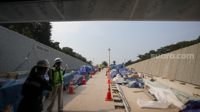 Pekerja menyelesaikan pembangunan MRT Fase 2A di Stasiun MRT Monas, Jakarta, Rabu (22/8/2025). [Suara.com/Alfian Winanto] 