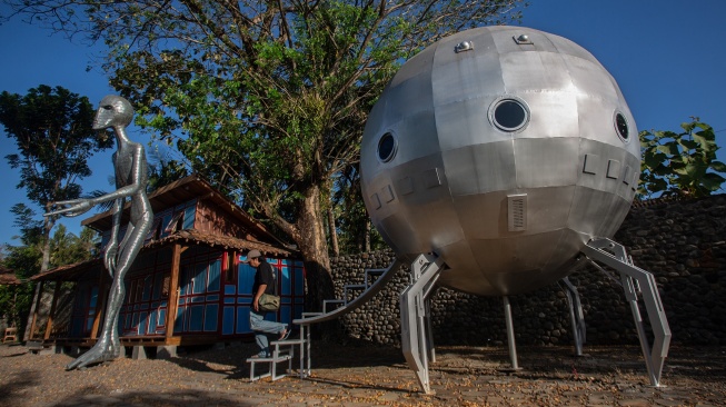 Pengunjung keluar dari karya yang dipamerkan saat Cosmos Exhibition di Kampung Alien, Nanggulan, Kulon Progo, D.I Yogyakarta, Selasa (21/7/2026). [ANTARA FOTO/Andreas Fitri Atmoko/sgd]
