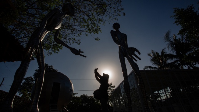 Pengunjung memotret karya yang dipamerkan saat Cosmos Exhibition di Kampung Alien, Nanggulan, Kulon Progo, D.I Yogyakarta, Selasa (21/7/2026). [ANTARA FOTO/Andreas Fitri Atmoko/sgd]