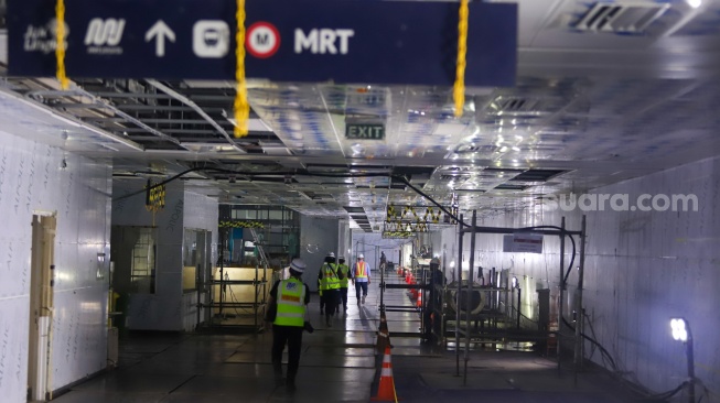 Pekerja menyelesaikan pembangunan MRT Fase 2A di Stasiun MRT Monas, Jakarta, Rabu (22/8/2025). [Suara.com/Alfian Winanto] 