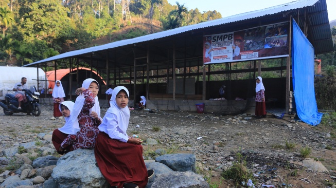 Sejumlah siswa berada di halaman ruang kelas Sekolah darurat Sekolah Dasar Negeri (SDN) 1 Beutong Ateuh Banggalang, Desa Kuta Teungoh, Nagan Raya, Aceh, Kamis (23/7/2026). [ANTARA FOTO/Syifa Yulinnas/nz]