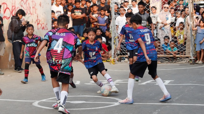  Para pemain saling berebut bola saat pertandingan Liga aspal 2026. [Suara.com/Alfian Winanto]