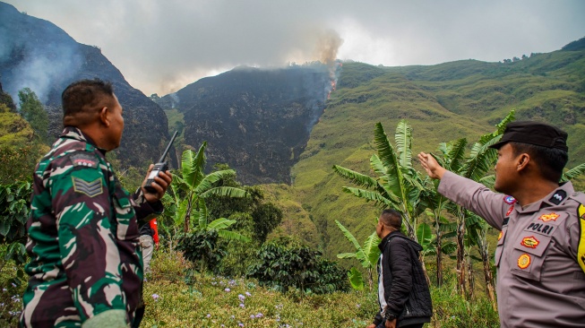 Petugas gabungan menunjukkan titik kebakaran hutan di kawasan Perhutani RPH Sukapura, Blok Gunung Ringgit, Desa Sapikerep, Kecamatan Sukapura, Kabupaten Probolinggo, Jawa Timur, Minggu (26/7/2026). [ANTARA FOTO/Irfan Sumanjaya/agr]