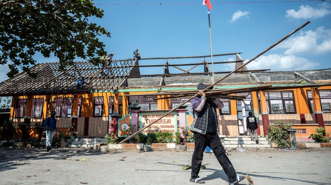 Pekerja memindahkan material bangunan dalam proyek revitalisasi SD Negeri Tanggirejo di Tegowanu, Grobogan, Jawa Tengah, Senin (27/7/2026). [ANTARA FOTO/Aprillio Akbar/tom]