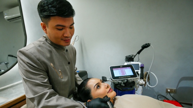 Seorang tenaga medis melakukan perawatan wajah menggunakan alat berbasis teknologi kepada pelanggan di sebuah klinik Dermalift di Jakarta, Senin (28/7/2026). [Handout]