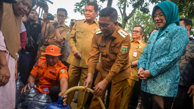 Gubernur Banten Andra Soni (kedua kanan) mengisi galon milik warga dengan air bersih disaksikan Bupati Tangerang Maesyal Rasyid (ketiga kanan) dan Ketua Tim Penggerak Pemberdayaan Kesejahteraan Keluarga (TP PKK) Provinsi Banten Tinawati Andra Soni (kanan) di Desa Margasari, Tigaraksa, Kabupaten Tangerang, Banten, Selasa (28/7/2026). [ANTARA FOTO/Putra M. Akbar/kye]