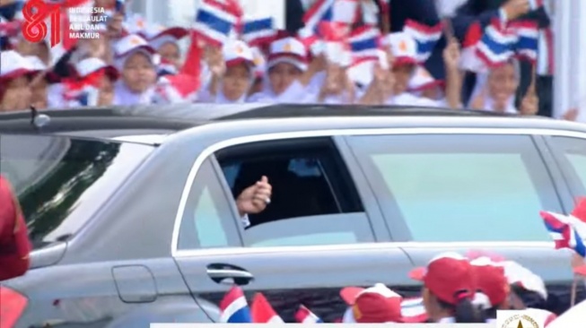 Perdana Menteri (PM) Thailand Anutin Charnvirakul membalas sambutan pelajar dengan membuka kaca mobilnya sambil menunjukkan gestur jari berbentuk hati di Istana Merdeka, Jakarta, Senin (3/8/2026). [Suara.com/Bagaskara]