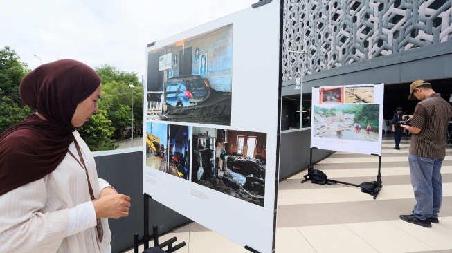 Pengunjung melihat karya pameran foto jurnalistik Prahara Pulau Emas di Museum Tsunami Aceh, Banda Aceh, Aceh, Senin (3/8/2026). [ANTARA FOTO/Akramul Muslim/agr]
