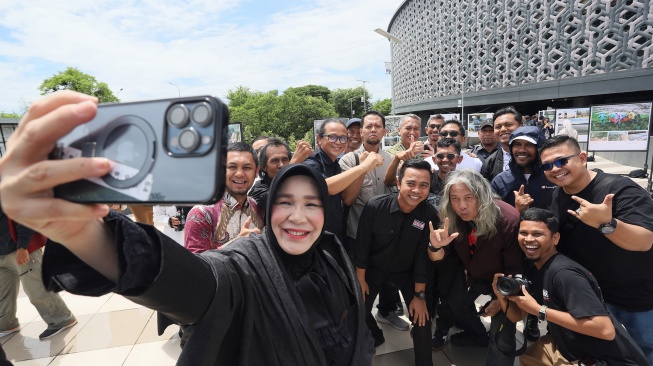 Wali Kota Banda Aceh Illiza Sa'aduddin Djamal (kiri) berfoto bersama sejumlah pewarta foto saat pameran foto jurnalistik Prahara Pulau Emas di Museum Tsunami Aceh, Banda Aceh, Aceh, Senin (3/8/2026). [ANTARA FOTO/Akramul Muslim/agr]