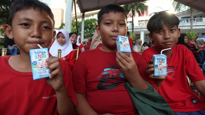 Anak-anak meminum susu pada acara peluncuran Susu Tango Kido Full Cream di Tribeca Park, Central Park, Jakarta Barat, Minggu (2/8/2026). [Handout]