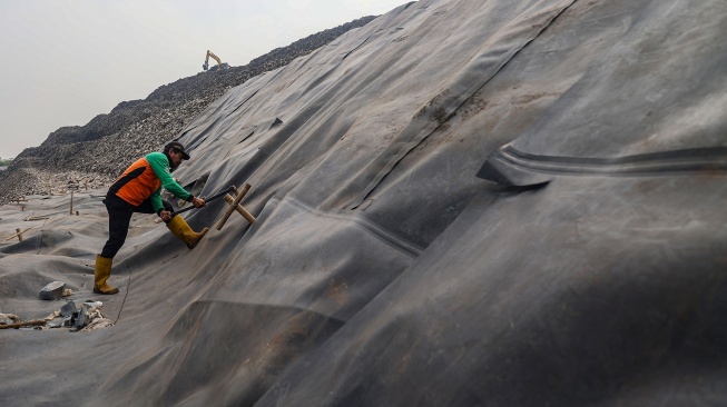 Petugas memasang patok pada geomembran sebagai media pelindung untuk menutup tumpukan sampah di Tempat Pengolahan Sampah Terpadu (TPST) Bantargebang, Kota Bekasi, Jawa Barat, Selasa (4/8/2026). [ANTARA FOTO/Darryl Ramadhan/kye]