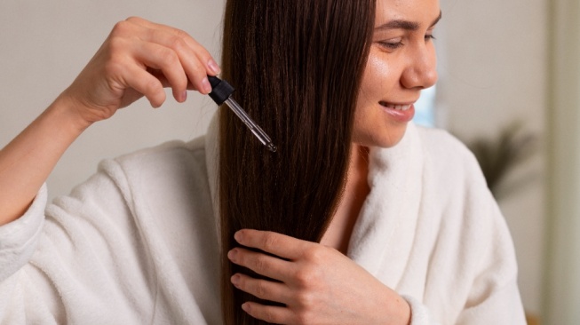 Ilustrasi memakai hair serum. (Magnific)