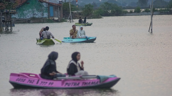 Wisatawan menaiki perahu kano menikmati suasana matahari tenggelam di area persawahan terdampak rob di Kandang Panjang, Kota Pekalongan, Jawa Tengah, Rabu (5/8/2026). [ANTARA FOTO/Harviyan Perdana Putra/foc]