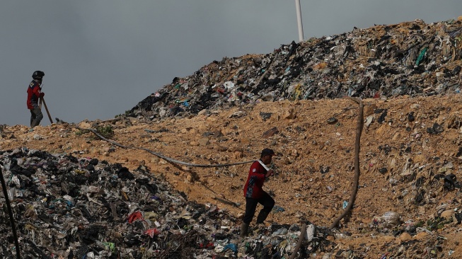 Relawan pemadam kebakaran menarik selang saat melintasi tumpukan sampah di Tempat Pembuangan Akhir (TPA) Rasau Jaya, Kabupaten Kubu Raya, Kalimantan Barat, Kamis (6/8/2026). [ANTARA FOTO/Jessica Wuysang/kye]
