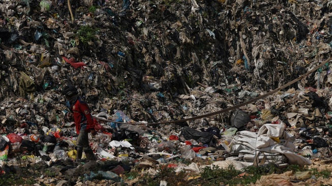 Dua personel Badan Penanggulangan Bencana Daerah (BPBD) Kabupaten Kubu Raya membawa selang saat melintasi tumpukan sampah di Tempat Pembuangan Akhir (TPA) Rasau Jaya, Kabupaten Kubu Raya, Kalimantan Barat, Kamis (6/8/2026). [ANTARA FOTO/Jessica Wuysang/kye]