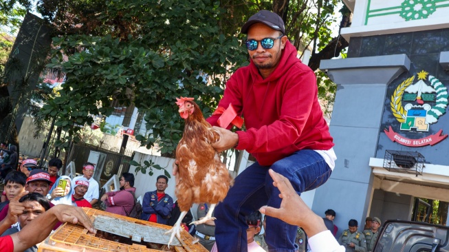 Peserta aksi yang tergabunng dalam Peternak Rakyat Sulawesi membagikan ayam saat aksi damai di depan kantor Gubernur Sulawesi Selatan, Makassar, Sulawesi Selatan, Senin (10/8/2026). [ANTARA FOTO/Arnas Padda/foc]
