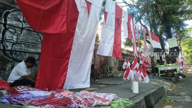 Pedagang bendera menjajakan dagangannya di pinggir jalan di kota Makassar. Setiap Agustus, banyak pedagang dari luar kota memanfaatkan momentum perayaan kemerdekaan mendapatkan rupiah [SuaraSulsel.id/Lorensia Clara]
