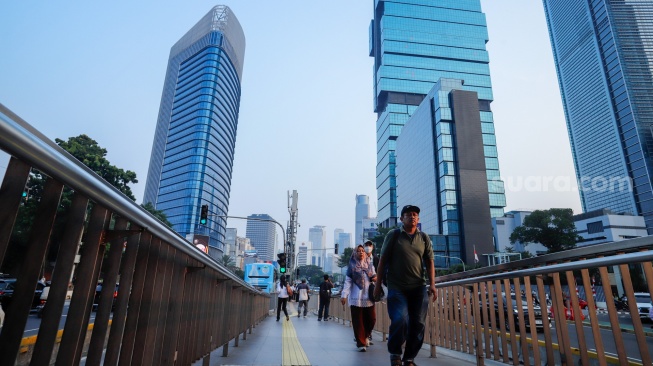 Para pekerja beraktivitas saat jam pulang kerja di kawasan Sudirman, Jakarta, Senin (10/8/2026). [Suara.com/Alfian Winanto]