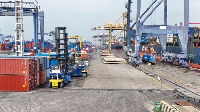 Suasana bongkar-muat peti kemas di Pelabuhan Jakarta International Container Terminal (JICT), Tanjung Priok, Jakarta, Rabu (12/8/2026). [Suara.com/Alfian Winanto]

