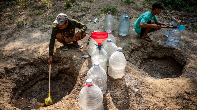 Sejumlah warga mengambil air dari belik yang dibuat di dasar sungai yang mengering di Dusun Ngedat, Desa Ketro, Grobogan, Jawa Tengah, Kamis (13/8/2026). [ANTARA FOTO/Aprillio Akbar/kye]
