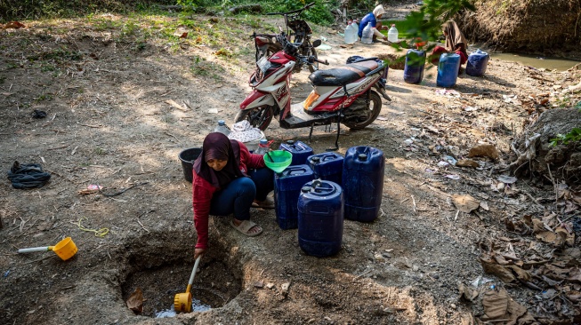 Sejumlah warga mengambil air dari belik yang dibuat di dasar sungai yang mengering di Dusun Ngedat, Desa Ketro, Grobogan, Jawa Tengah, Kamis (13/8/2026). [ANTARA FOTO/Aprillio Akbar/kye]