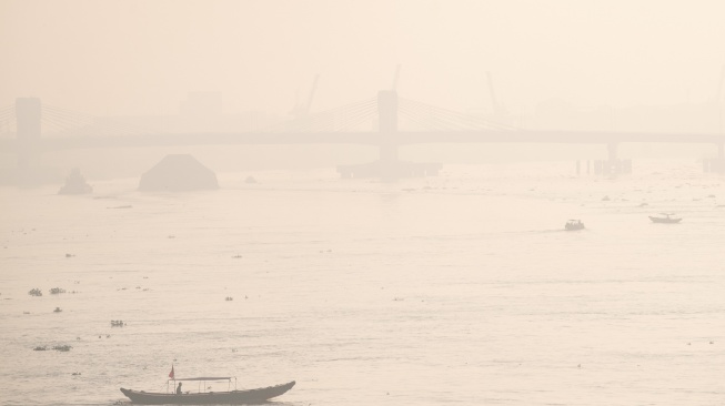 Sejumlah kapal tradisional melintas di perairan sungai musi yang diselimuti kabut asap di Palembang, Sumatera Selatan, Kamis (13/8/2026). [ANTARA FOTO/Nova Wahyudi/YU]