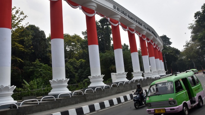 Angkutan kota melintas di samping monumen Tepas Salapan Lawang Dasakreta, Otista, Kota Bogor, Jawa Barat, Rabu (12/8/2026). [ANTARA FOTO/Arif Firmansyah/nym]