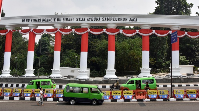 Angkutan kota melintas di samping monumen Tepas Salapan Lawang Dasakreta, Otista, Kota Bogor, Jawa Barat, Rabu (12/8/2026). [ANTARA FOTO/Arif Firmansyah/nym]