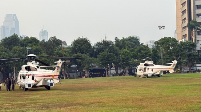 Dua helikopter kenegaraan bersiaga di lapangan Kompleks Parlemen, Senayan, Jakarta, Jumat (14/8/2026). [Suara.com/Bagaskara]