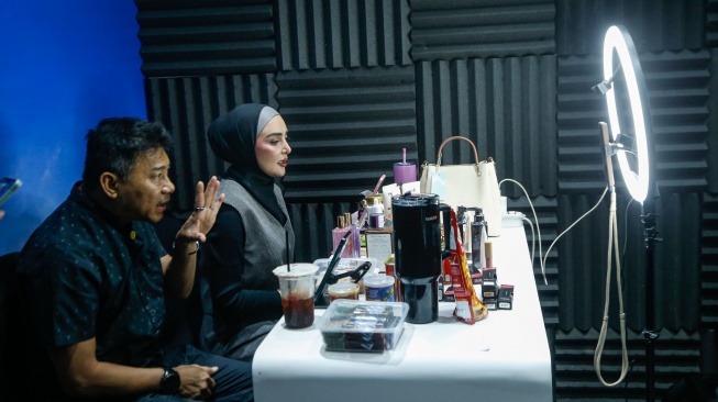 Publik Figur Anang Hermansyah dan Ashanty melakukan pemasaran melalui siaran langsung platform digital saat acara Perayaan Kolaborasi #BeliLokal di Jakarta, Kamis (13/8/2026). [Suara.com/Alfian Winanto]