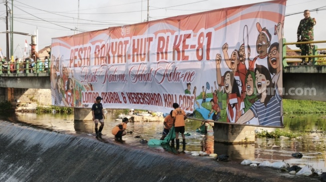 Warga Kota Yogyakarta bersih-bersih sembari mural di RTHP Taman Perwita Sungai Code di Kalurahan Prawirodirjan, Gondomanan, Kota Yogyakarta, Jumat (14/8/2026).[Suarajogja.id/Putu Ayu Palupi]