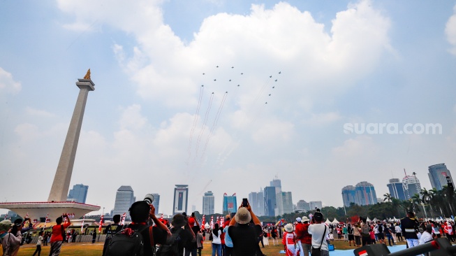 Warga melihat sejumlah pesawat jet tempur TNI AU yang terdiri dari F-16, Rafale dan Sukhoi membentuk formasi 81 saat terbang usai Upacara Peringatan Detik-Detik Proklamasi Kemerdekaan ke-81 Republik Indonesia di Monumen Nasional (Monas), Jakarta, Senin (17/8/2026). [Suara.com/Alfian Winanto]