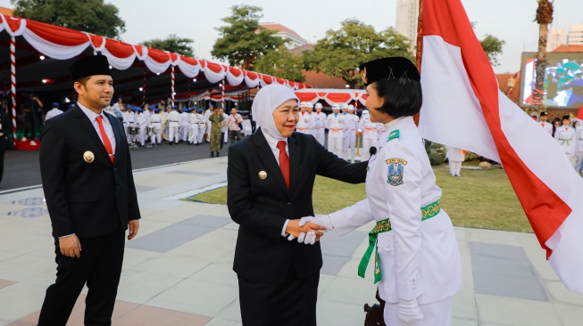 Gubernur Jawa Timur Khofifah Indar Parawansa didampingi Wakil Gubernur Jawa Timur Emil Dardak saat mengukuhkan 76 anggota Pasukan Pengibar Bendera Pusaka (Paskibraka) Provinsi Jawa Timur Tahun 2026 di Halaman Gedung Negara Grahadi, Surabaya, Minggu (16/8/2026) sore. (Dok: Pemprov Jatim)