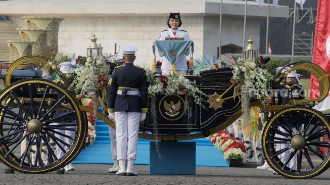 Purna Paskibraka 2025 Sultana Najwa membawa baki duplikat Bendera Pusaka Merah Putih menuju Kereta Kencana Garuda Prabayaksa saat Kirab Merah Putih HUT ke-81 Republik Indonesia di Monas, Jakarta, Senin (17/8/2026).&nbsp;[Suara.com/Alfian Winanto]