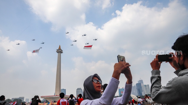 Jupiter Aerobatic Team (JAT) TNI AU membentuk formasi saat terbang usai Upacara Peringatan Detik-Detik Proklamasi Kemerdekaan ke-81 Republik Indonesia di Monumen  Nasional (Monas), Jakarta, Senin (17/8/2026). [Suara.com/Alfian Winanto]